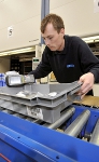 A conveyor and sortation system transfers items from the picking face to order rework and assembly areas at the front of the building.